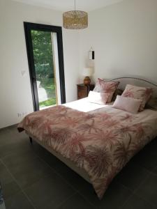 um quarto com uma cama grande e almofadas cor-de-rosa em Charmante Maison neuve au Lac d'Hourtin em Hourtin