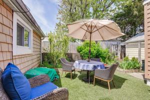 une terrasse avec une table, des chaises et un parasol dans l'établissement Point Lookout Cottage - Walk to Beach!, 