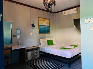 a small bedroom with a bed and a desk and a bed sqor at Paksina Hotel in Narathiwat