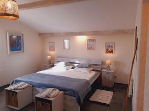 een slaapkamer met een groot bed en 2 nachtkastjes bij BnB Ferme Beauregard Les Pyrénées in Artigat