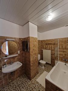 ein Badezimmer mit einem Waschbecken, einer Badewanne und einem WC in der Unterkunft Hotel Aurichs in Meersburg