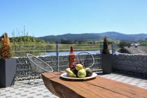 a plate of fruit on a table with a bottle of wine at Black&White Luxus Appartement - Wilbergé Chalets in Gotteszell