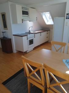 una cucina e una sala da pranzo con tavolo e sedie di West coast villa with sea view a Skärhamn