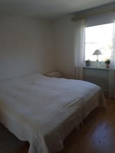 uma cama branca num quarto com uma janela em West coast villa with sea view em Skärhamn