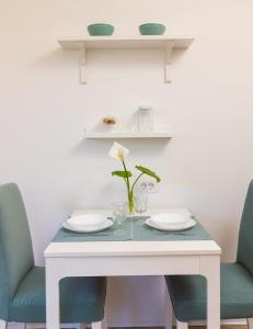 a white table with two chairs and a vase with a flower at Apartment Judita in Dubrovnik