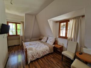 ein Schlafzimmer mit einem Bett, einem Tisch und einem Stuhl in der Unterkunft Hotel Aurichs in Meersburg