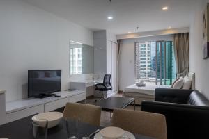 a living room with a bed and a room with a television at MyRehat Suites Bukit Ceylon in Kuala Lumpur