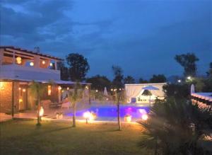 una casa con piscina notturna con luci di White Diamond Villa a Kamena Vourla