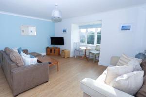 a living room with two couches and a tv at Tankerton Town House, 1 parking space, 150m beach in Whitstable