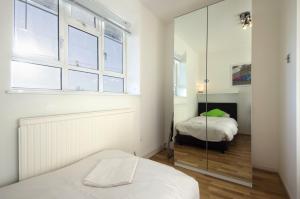 ロンドンにあるCentral London 2 Bedroom Apartmentのベッドルーム1室(ベッド2台、鏡付)