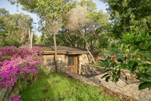 a stone house with a garden and flowers at Captain Ikaros in Agios Kirykos