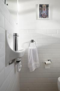a white bathroom with a sink and a towel at Central London 2 Bedroom Apartment in London