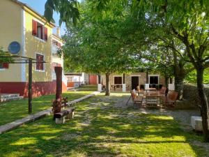 a yard with benches and a table and a tree at Kuća za odmor Dolovi in Golubić