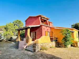 a small red and yellow house with a yard at Rena Majore in vacanza in Rena Majore