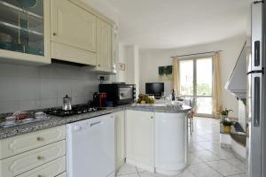 eine Küche mit weißen Schränken und einer Arbeitsplatte in der Unterkunft casa vacanza Luciano in Tortolì