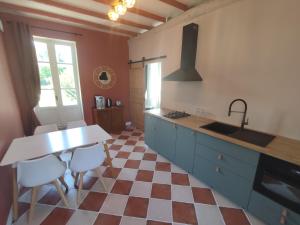 a kitchen with a checkered floor and a sink and a counter at Au tournebride in Randan