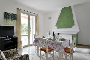 ein Esszimmer mit einem Tisch und einem TV in der Unterkunft casa vacanza Luciano in Tortolì