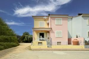 ein rosa und gelbes Haus mit einem Balkon in der Unterkunft casa vacanza Luciano in Tortolì