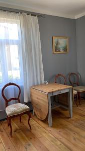 a wooden table and two chairs in a room at Skrunda Apartments Elvira in Skrunda