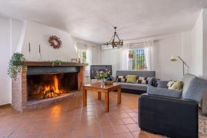 a living room with a fireplace and a couch at El Cortijo de Granada in Gójar