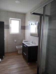 La salle de bains est pourvue d'un lavabo et de toilettes. dans l'établissement Alojamiento Cabarceno, à Agüero