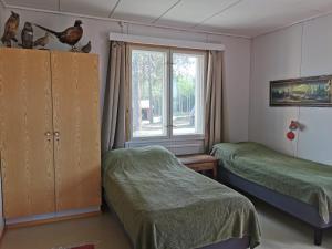 1 Schlafzimmer mit 2 Betten und einem Fenster in der Unterkunft Ulvovan Suden Majatalo 