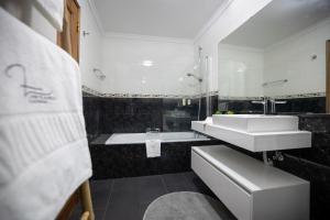 a white bathroom with a sink and a tub at Lino's Family in Peso da Régua +19 photos