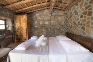 een slaapkamer met een bed met een teddybeer erop bij Captain Ikaros in Agios Kirykos