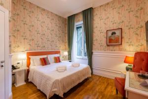 una camera con un letto in una stanza con carta da parati di Mangili Garden Hotel a Roma