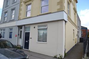 a white and yellow building on the side of a street at Thomas 1 bed Apartment with cathedral views - STAYSEEKERS in Salisbury