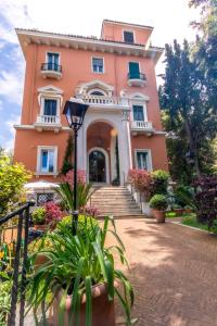 una casa rosa con scale e piante di fronte di Mangili Garden Hotel a Roma