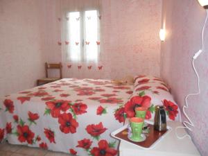 a bedroom with a bed with red flowers on it at agriturismo heaven trilocale 2 in Ricadi