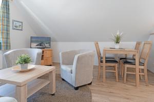 uma sala de estar com duas cadeiras e uma mesa em Fahrenkrug Wohnung 1 em Scharbeutz