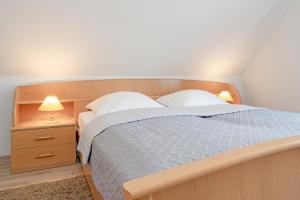 um quarto com uma cama e uma mesa de cabeceira com 2 candeeiros em Fahrenkrug Wohnung 1 em Scharbeutz