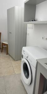 a washer and dryer in a white kitchen at Villa Sun Sky in Aggelika