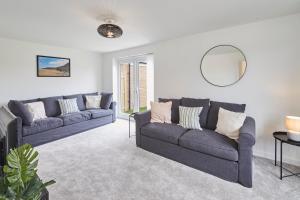 a living room with two couches and a mirror at Host & Stay - Cayton Bay Cottage in Cayton