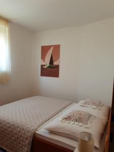 a bedroom with a bed with a painting on the wall at Princess in Brodarica