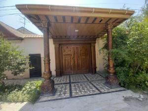 a wooden entrance to a house with a wooden door at Апартаменты Registan in Samarkand