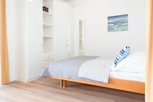 1 dormitorio con paredes blancas y 1 cama con almohadas azules en Am Hang 13 Wohnung 18, en Scharbeutz
