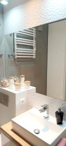 ein Badezimmer mit einem weißen Waschbecken und einem Spiegel in der Unterkunft Apartament Rodzinny Przy AquaParku in Reda