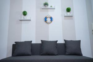 Un sofá sentado en una sala de estar con plantas. en Sunset Apartment Palese - A 10m dal mare, en Bari