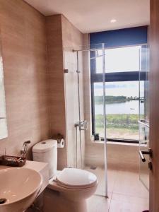 a bathroom with a shower and a toilet and a sink at Golden sunshine studio-Sea view &Nelflix Free in Ha Long