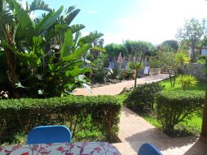 un patio con mesa y sillas y un jardín en agriturismo heaven trilocale 3, en Ricadi
