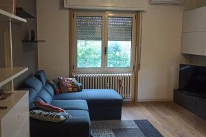 ein Wohnzimmer mit einem blauen Sofa und einem Fenster in der Unterkunft Casa Anna Big House Near Lake Garda and Centre in Salò