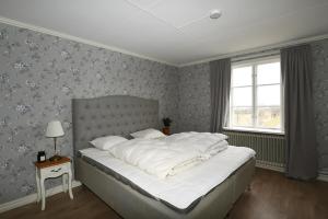1 dormitorio con 1 cama blanca grande y ventana en Spacious house in Hjo by Vattern with fantastic views en Tidaholm