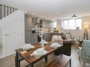 a kitchen and living room with a table and chairs at The Old School in Cinderford