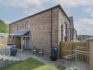 a brick house with a deck and a patio at The Old School in Cinderford