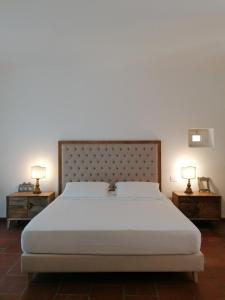 a bedroom with a large white bed with two night stands at Palazzo De Mori in Otranto