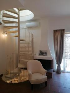 a living room with a spiral staircase and a chair at Palazzo De Mori in Otranto