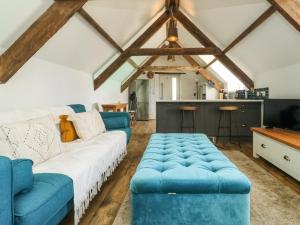 a living room with a blue couch and a kitchen at The Loft in Plymouth